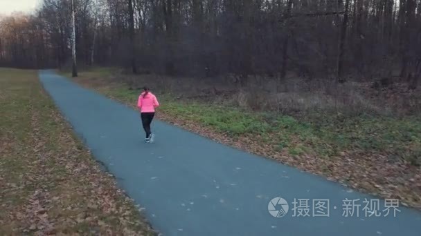 在夕阳下奔跑的女人的鸟瞰图视频