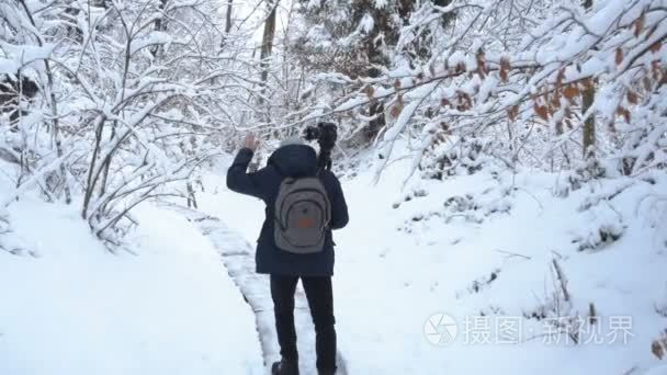 摄影师在冬山。长胡子的人走过乌克兰喀尔巴阡山的冬天森林