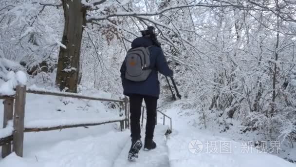 摄影师在冬山。长胡子的人走过乌克兰喀尔巴阡山的冬天森林