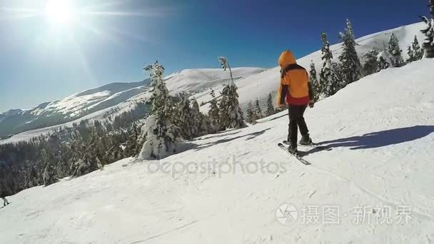 女人血统上滑雪板从雪山山脉视频