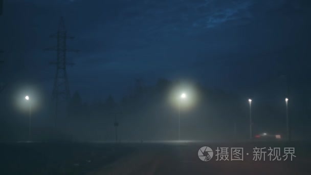 一辆汽车转向令人惊叹的黑夜高速公路。令人难以置信的大气电影拍摄。风光的天空和散的城市灯光