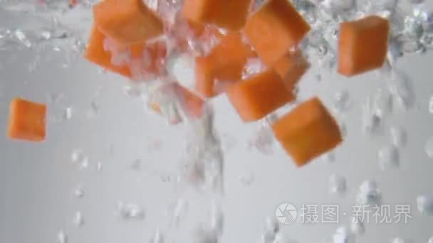 胡萝卜片掉进沸腾的水里。宏视图