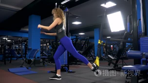 年轻迷人的女人做核心 abs crossfit 斜训练与健身带在健身房工作室。trx视频
