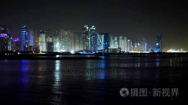 迪拜市中心的夜晚倒映在水中。城市夜景  市区全景  倒映在水中  迪拜。迪拜市区夜景与水的倒影  新城市的现代设计