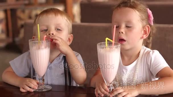 两个孩子在户外咖啡馆喝奶昔视频