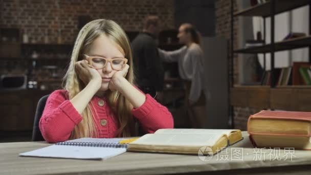 心烦意乱的女孩学习, 而她的父母打架