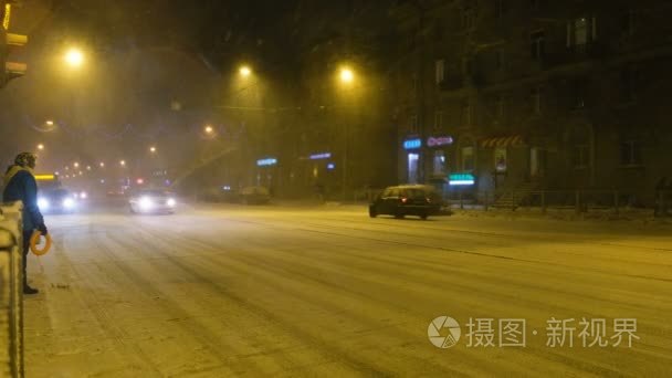 在冬天的晚上, 人们在雪地里过马路4k