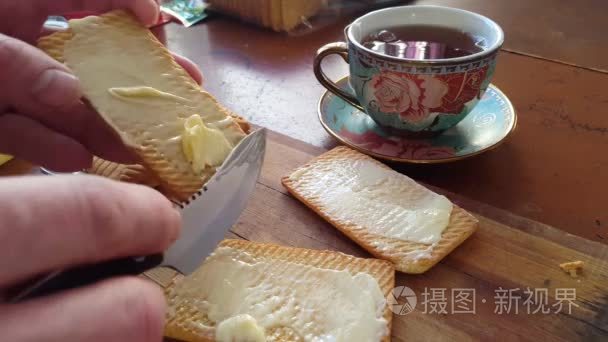 用刀子把黄油撒在小麦饼干上视频