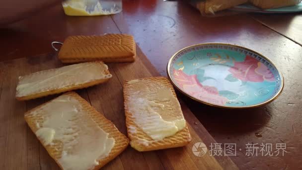 用刀子把黄油撒在小麦饼干上视频