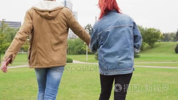 年轻夫妇手拉手在城市公园散步视频