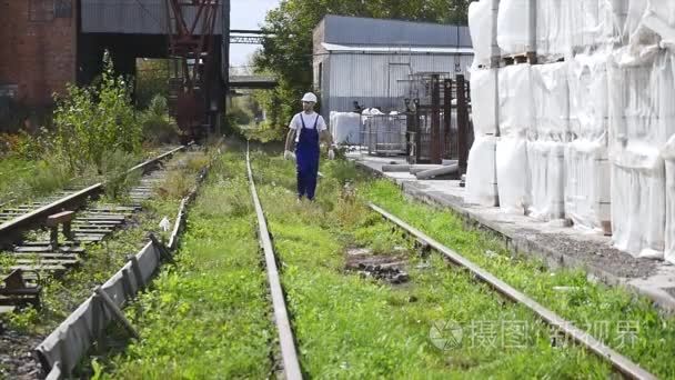 铁路工作者在白色盔甲沿铁路走视频