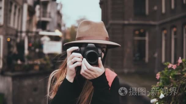 幸福的白种女人的肖像与相机。迷人的欢快的女士在时尚的帽子拍照4k 前视图