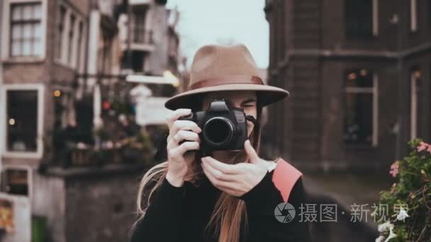 兴奋的女博客的肖像与相机。漂亮的微笑的女士拿着照片看着相机。4k 前视图