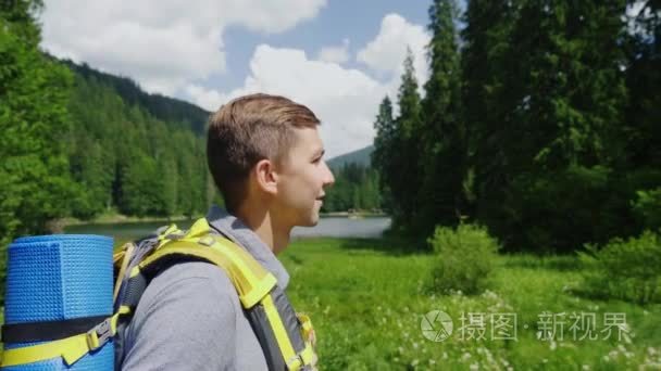 一个有吸引力的游客去一个风景如画的地方  在草地  山和天空的背景。旅游和积极的生活方式