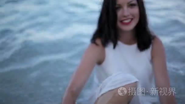 年轻迷人的女孩在海滩上摆姿势视频