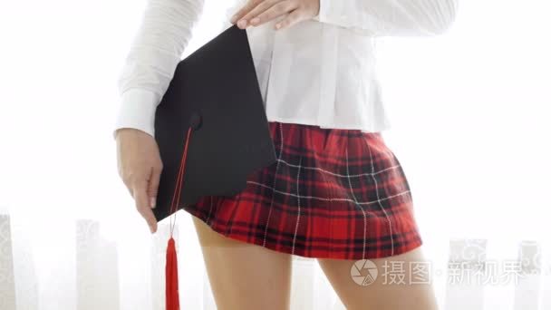 4k 短片的性感学生女孩在短红裙持有 mortarboard 帽视频