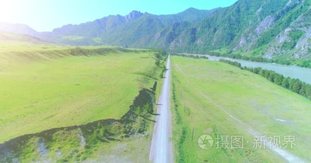 在晴朗的夏日清晨  空中的乡村山路和草地。沥青公路与河道