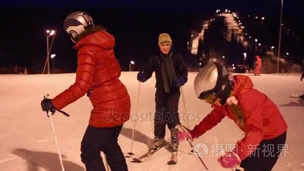 妇女和孩子滑雪在山在冬天夜视频