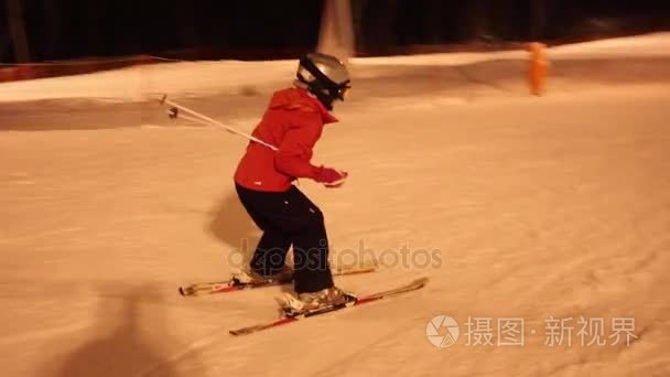 女童滑雪者在冬夜斜坡视频