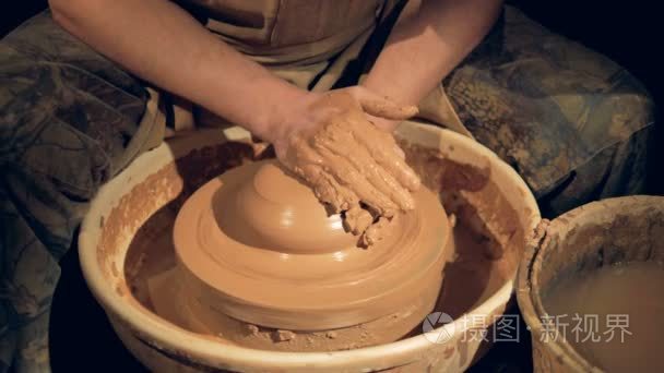 一个陶工在掷轮子时增加水分视频