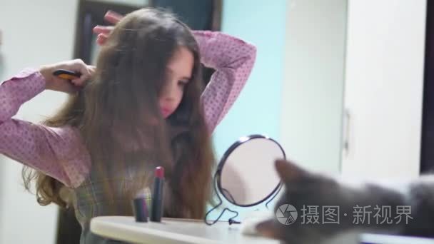 小女孩梳头发室内做发型。少女的头发梳和镜子