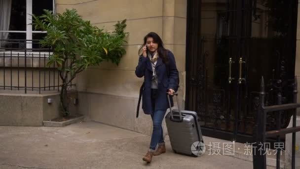 中国女孩离开大学建设与手提箱和智能手机交谈慢动作