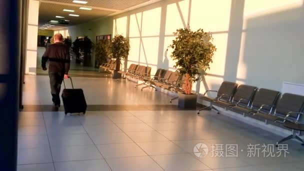 机场旅客步行及手提箱的后视视频