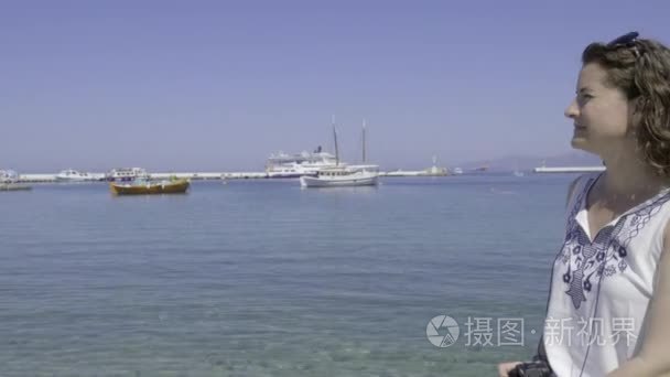 在滨海米科诺斯岛拍摄女性游客视频