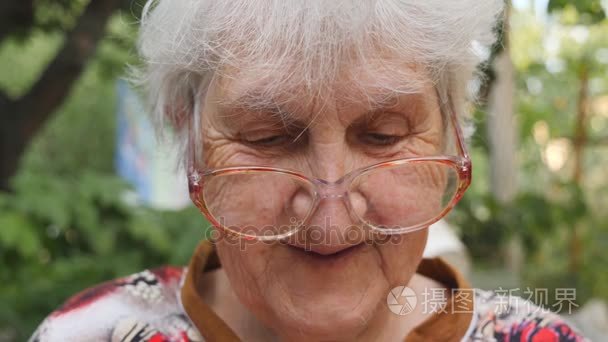 戴眼镜的快乐老奶奶的画像花时间在外面.祖母的情绪.关闭慢动作短视频