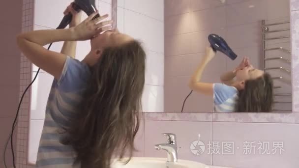 美丽的女孩年轻的头发干燥头发烘干机和唱歌和舞蹈在镜子前面在浴室股票录像视频
