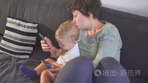 妈妈和儿子正在看他们的智能手机。小工具成瘾概念