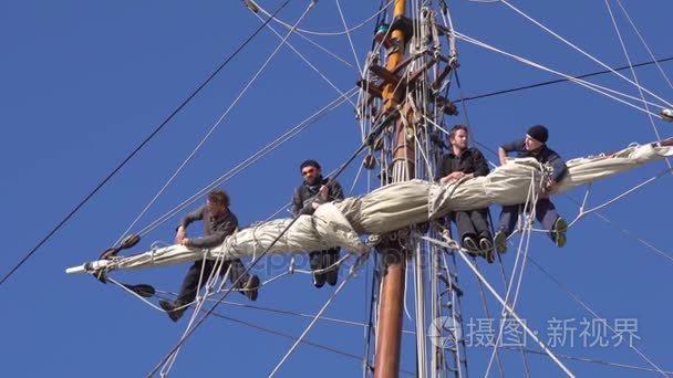 水手在传统帆船的高度上工作视频