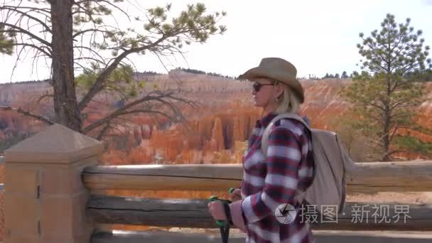 妇女游人徒步旅行到背景橙色红色砂岩山布莱斯峡谷