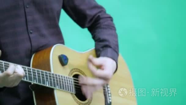 一只手在绿色背景上弹吉他视频