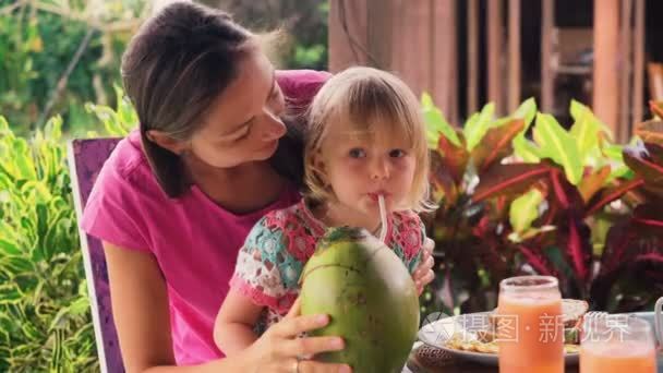 母亲帮助小女儿喝椰子汁视频