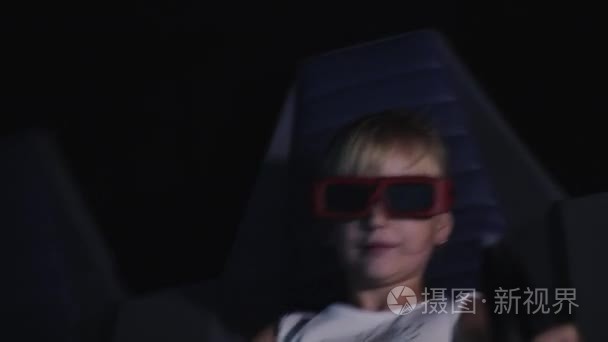 这个孩子正在电影院看3d 电影, 有特效和移动椅子