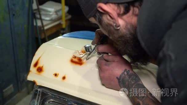 肖像成人大胡子艺术家在盖帽绘画集中与喷在汽车罩视频