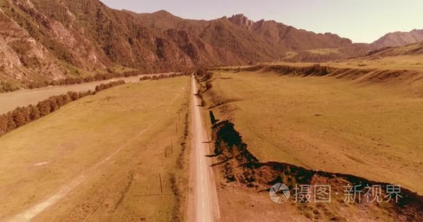 在晴朗的夏日清晨  空中的乡村山路和草地。沥青公路与河道