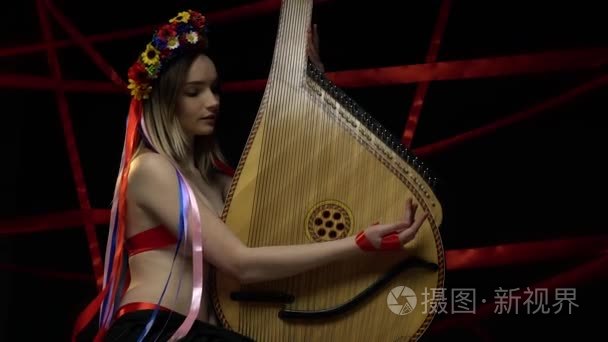 一个年轻的女孩在传统的乌克兰乐器上玩耍班杜拉