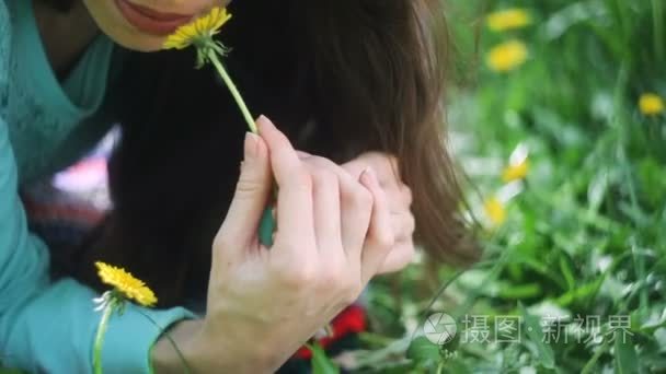 美女在草地上。美丽的年轻女孩在户外。享受大自然。健康微笑的女孩躺在绿色的草地上, 野花。欢笑和快乐