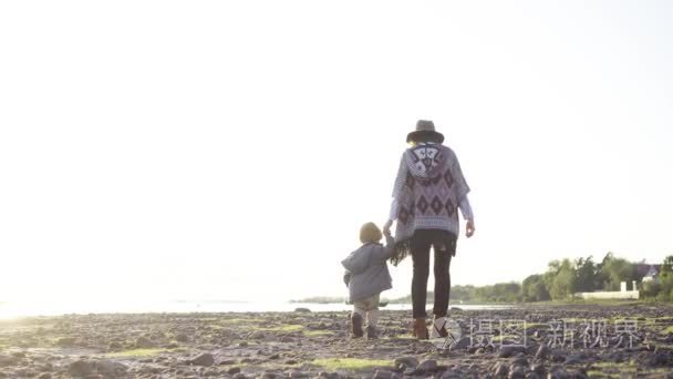妈妈和一个小男孩在沙滩上漫步