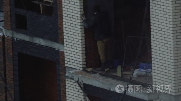 建设者把砖砌在建筑工地