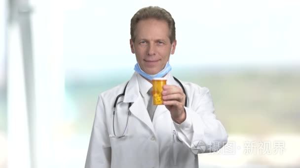 成熟微笑的医生提供药片罐头