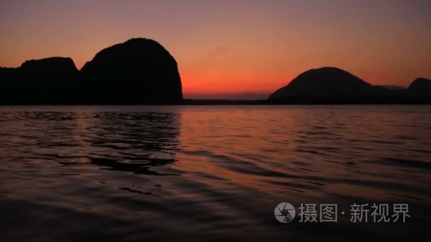 浪漫的紫色日落越过山脉的海洋视频