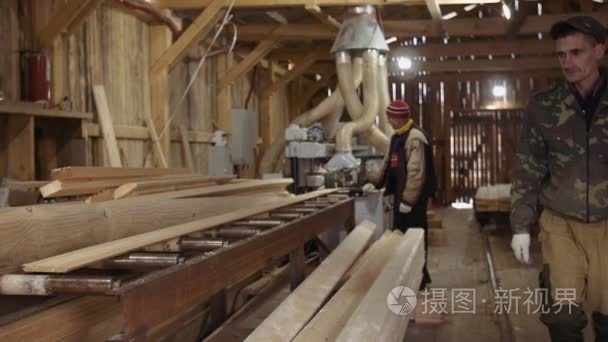 木工搬运木板放在锯木厂的包里视频