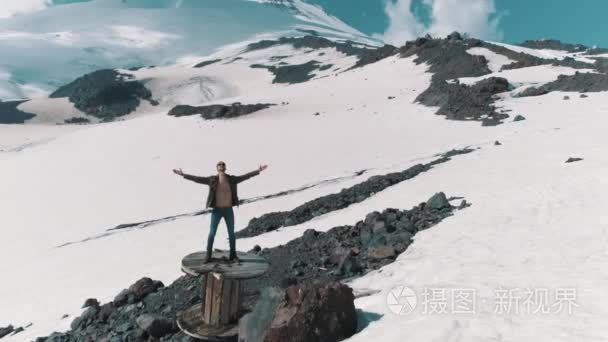 空中风景人上升胳膊站立在缆绳线轴在雪山岩石视频