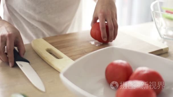 厨房慢动作切板上切番茄的妇女视频