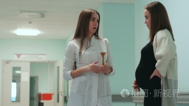 医院走廊中孕妇与女医生的对话视频