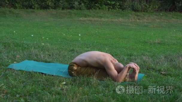 裸躯干的家伙做瑜伽体式, 清晨在城市公园锻炼