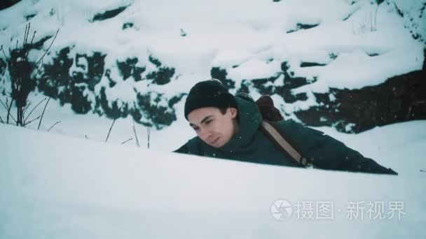 攀登山边的年轻人在雪被盖了视频